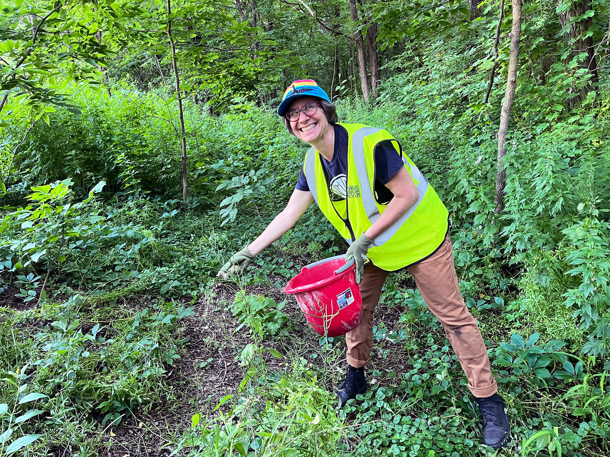 Carrie spreads native seeds in the woods