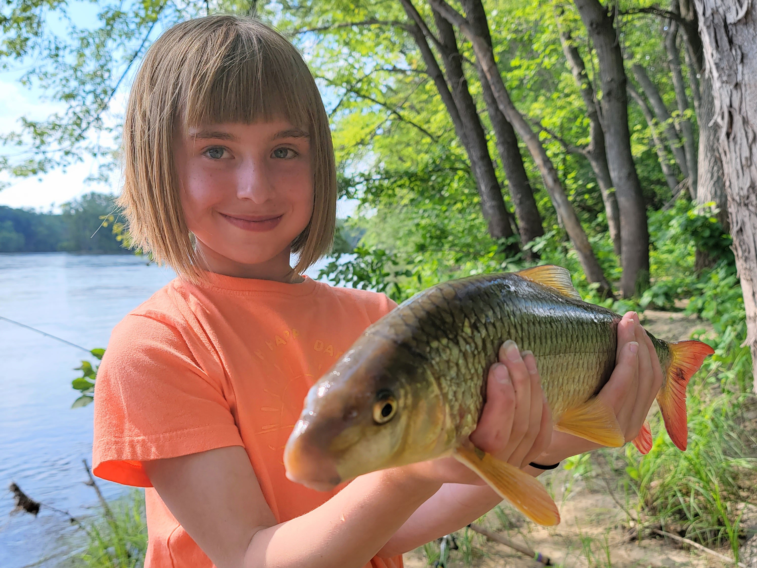 Child holds a shorthead redhorse fish