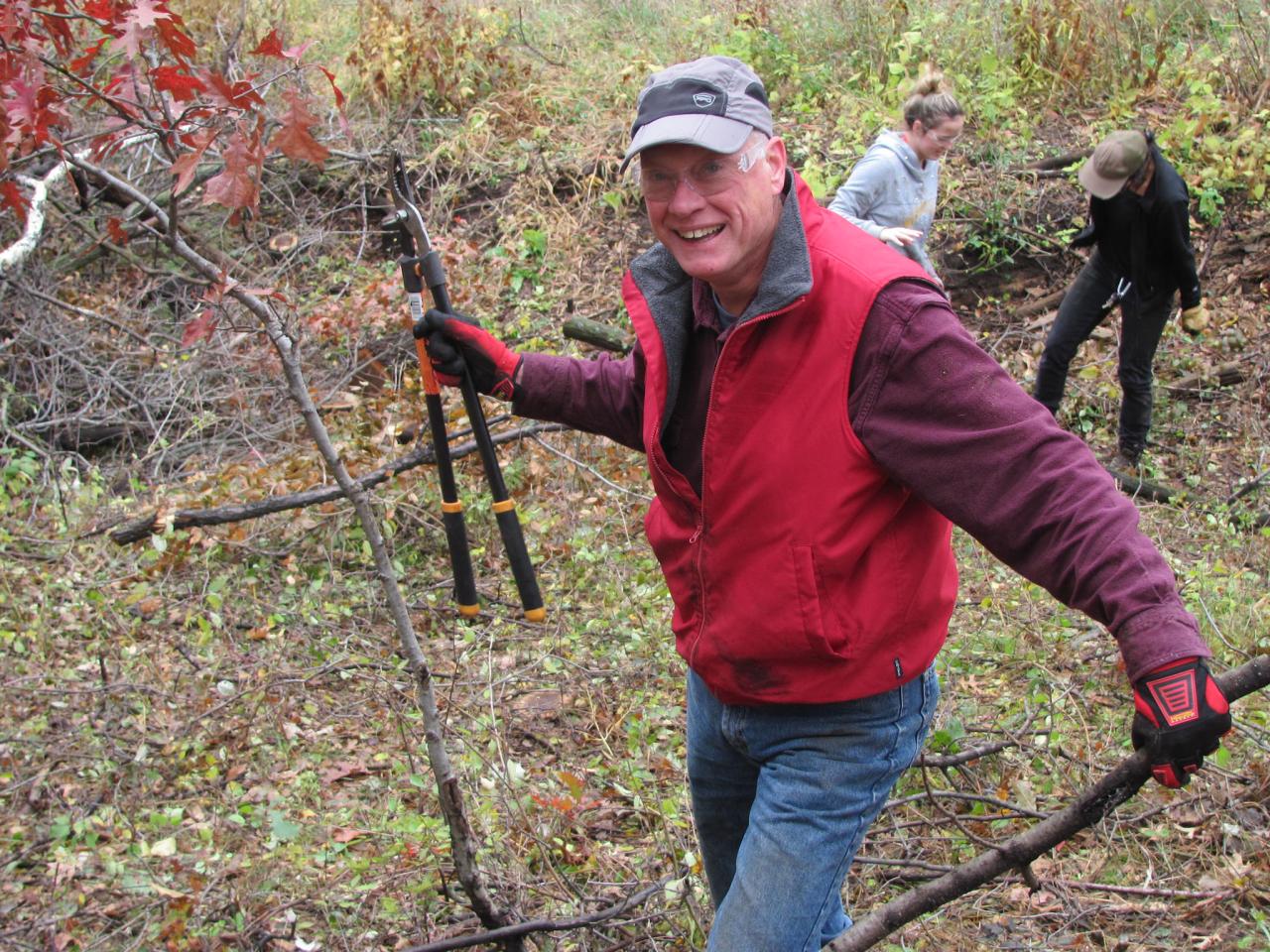 Volunteer with lopper and buckthorn in hand