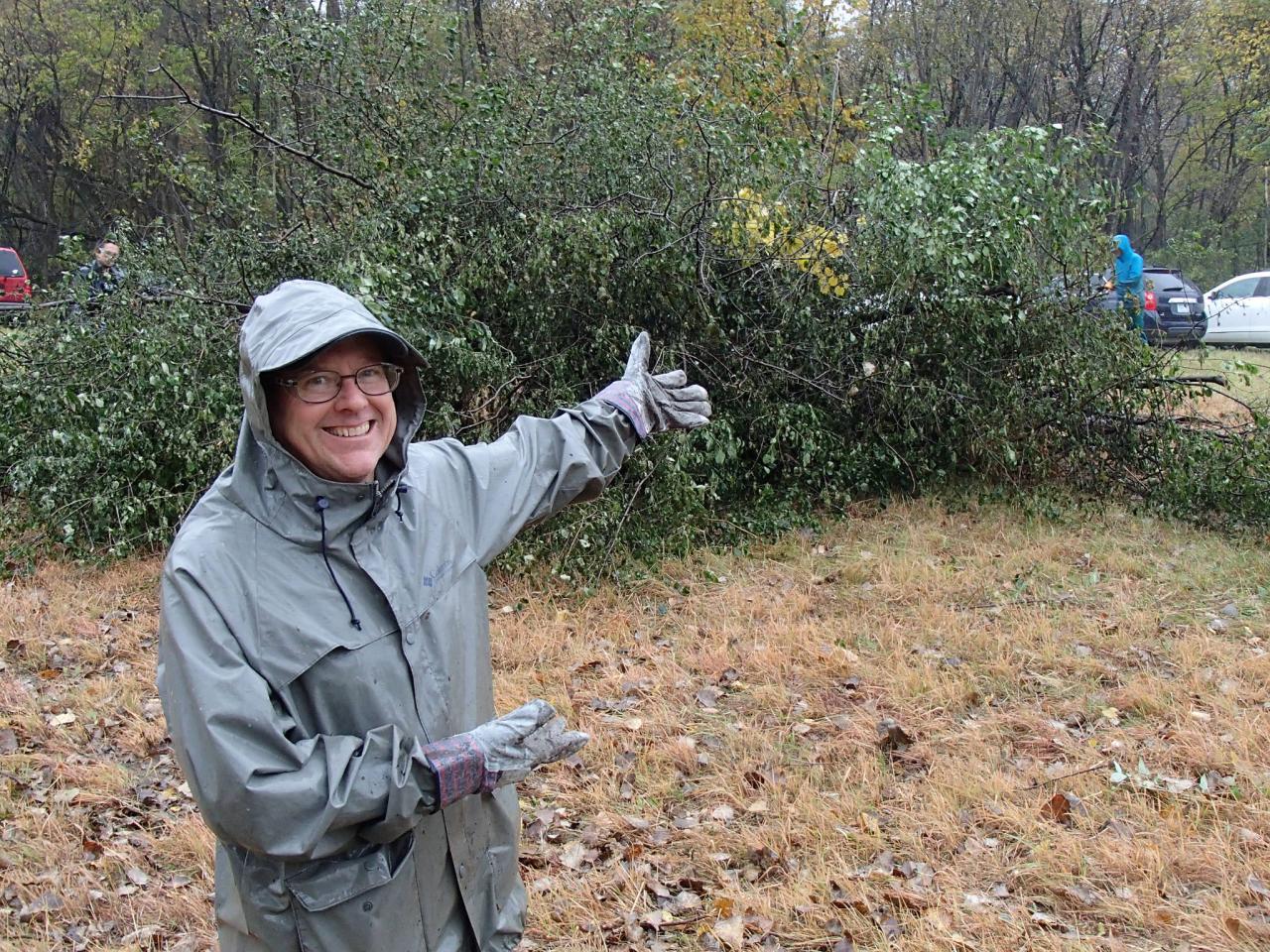 A volunteer showing off the large pile of brush that was the result of a hard day's work at last year's event.