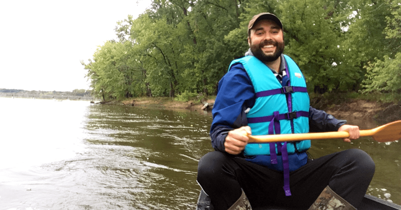 Adam Flett paddles a canoe