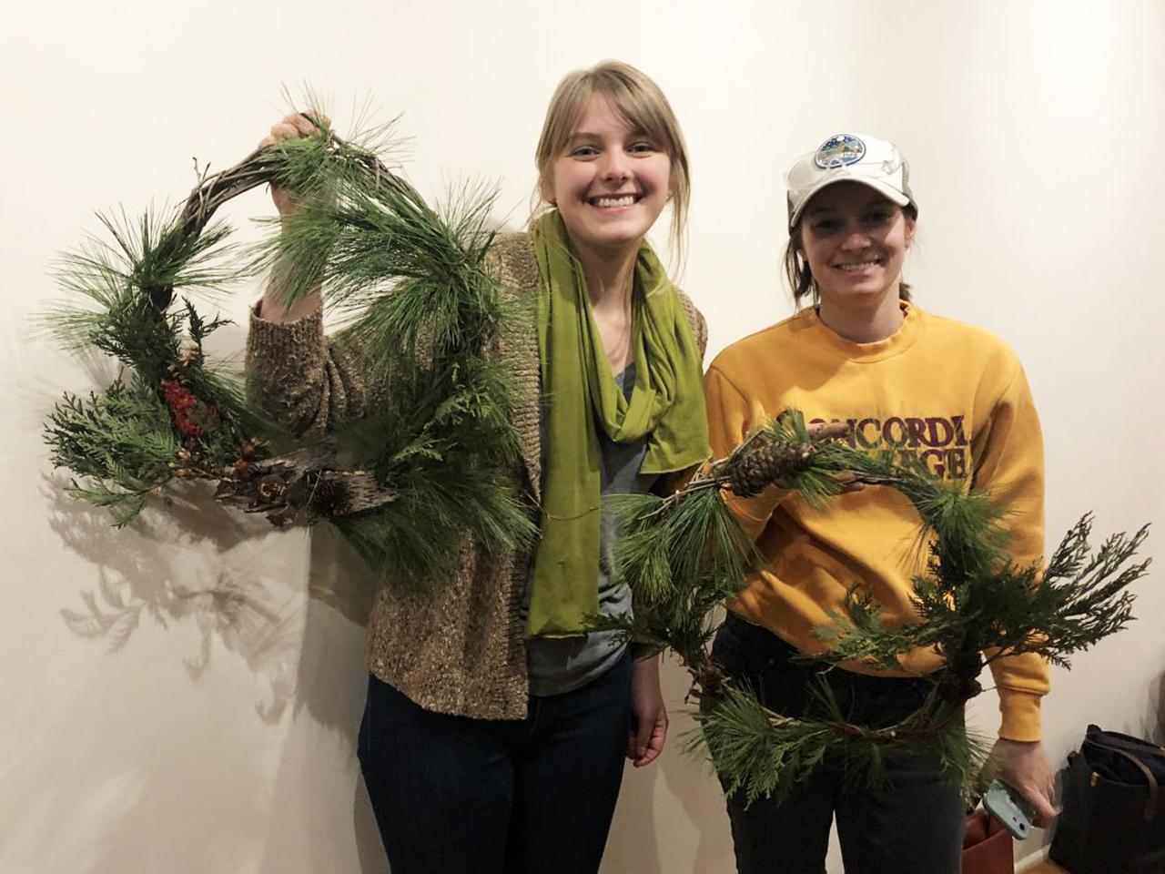 Two workshop participants display their buckthorn wreath creations.