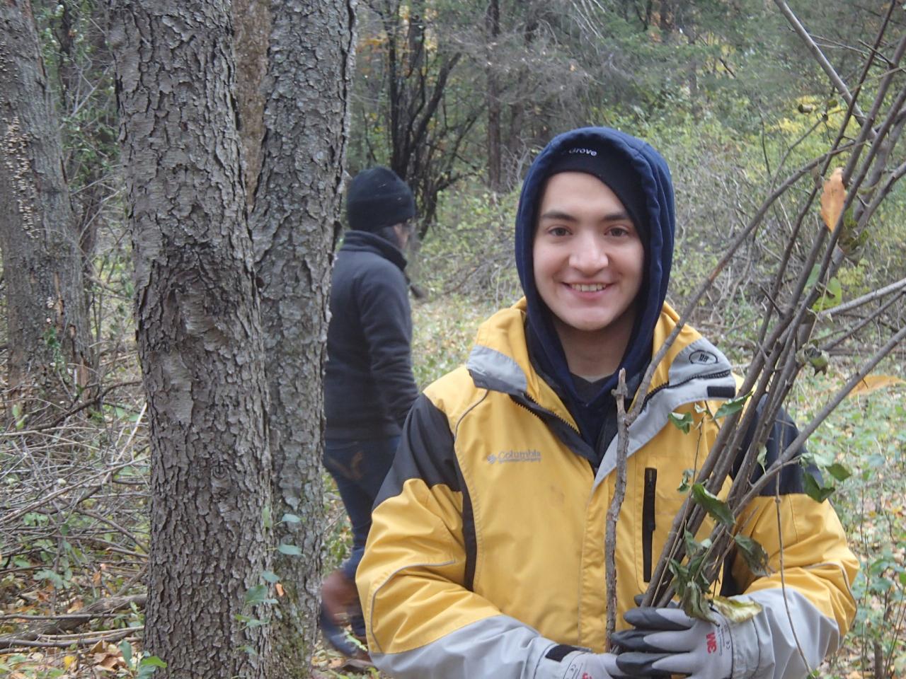 A volunteer poses with buckthorn sticks at a past Ravine Park brush haul