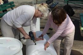 Workshop participants assembling a rain barrel