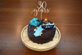 Chocolate cake with decoration: 30 years, canoe, tent, river, bonfire