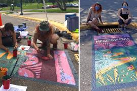 Artists work on mural and pose with finished mural