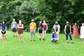 Program participants stand in grass