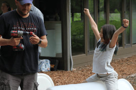 Two people putting together a rain barrel