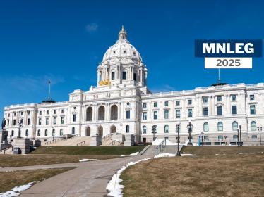 The Minnesota Capitol building in St. Paul, with a blue sky and a smattering of snow on the ground. Small text says "MNLEG 2025"